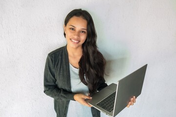 Young half-breed with straight hair using a laptop and smiling