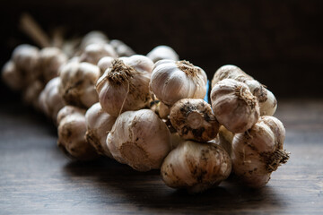 wreath of garlic on a dark wooden background