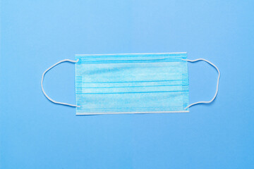 Medical disposable surgical face protective mask on blue background