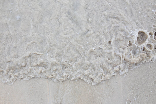 Sand on the beach as background. ocean wave on tropical sandy beach in summer.