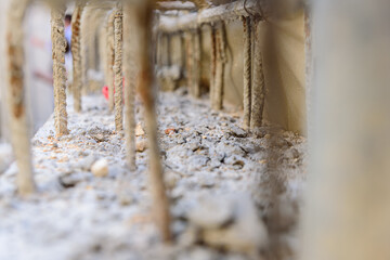 Reinforced concrete with steel bars makes the structure of a building resistant, detail with unfocused background.