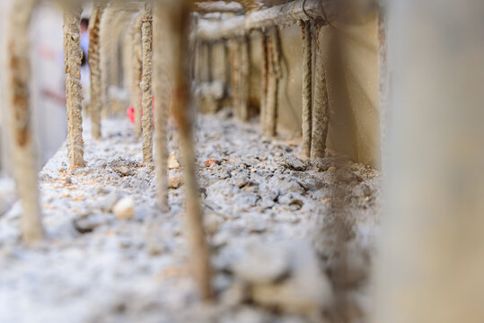 Reinforced concrete with steel bars makes the structure of a building resistant, detail with unfocused background.