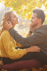 Happy young couple outdoors on a beautiful autumn day in the forest