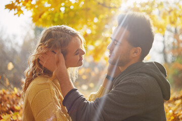 Happy young couple outdoors on a beautiful autumn day in the forest