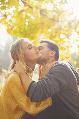 Happy young couple outdoors on a beautiful autumn day in the forest