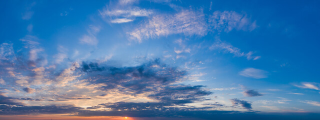 A beautiful sunrise panorama with gorgeous blue, yellow, orange and pink clouds. With sunbeams on a...