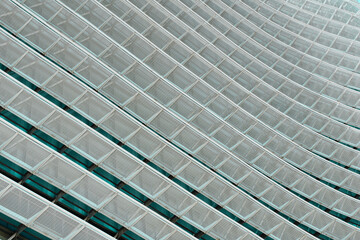 Metal grid background. Elegant facade of the building with blue glass windows.