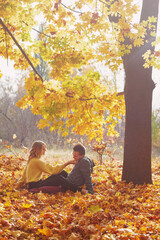 Happy young couple outdoors on a beautiful autumn day in the forest