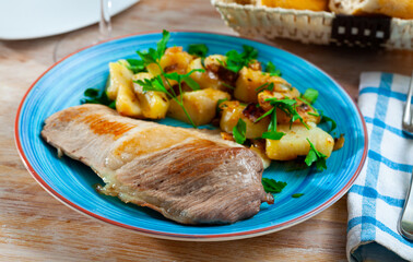 Grilled pork chop steak on plate served with fried potatoes