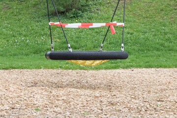Corona virus quarantine lockdown prohibit playground swings. Closure by barrier tape. Covid-19...