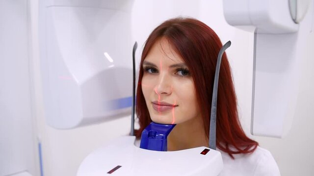 A woman patient makes a panoramic X-ray of the oral cavity using an orthopantomographic apparatus. close-up