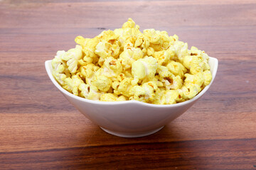 Tasty popcorn in a bowl on Wooden Background. Snack for a movie