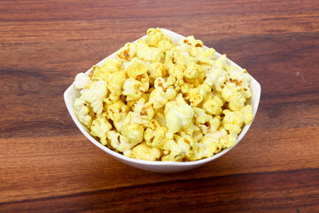 Tasty popcorn in a bowl on Wooden Background. Snack for a movie
