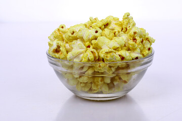 Popcorn in a Glass bowl on dark background. Snack for a movie