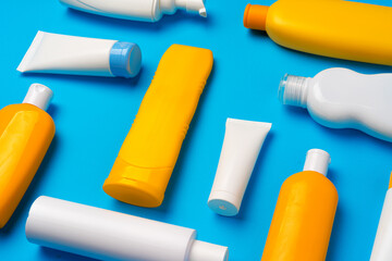 Bottles of sunscreen cream on blue background