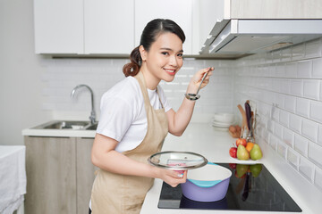 beautiful housewife cooking with ladle  in kitchen