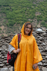 happy girl in yellow rain coat in village