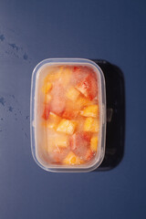 Frozen bell pepper in plastic container package on blue background.Healthy food concept