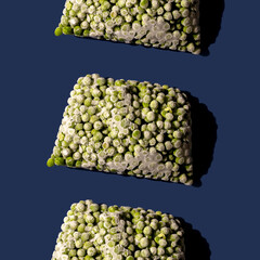 Pattern of frozen green pea on blue background.Modern abstract food concept