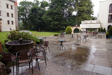 Empty tables in the castle courtyard during the rain