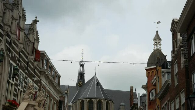 Static wide shot of medieval architectures and church in Alkmaar during cloudy day