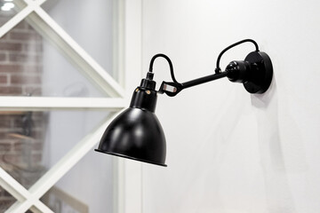Close up view of single Black modern wall lamp on white wall loft style