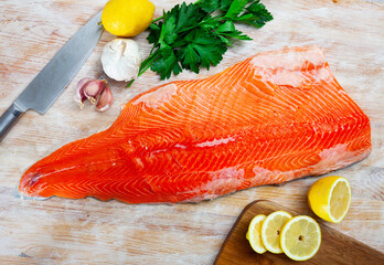 Salmon fillet on cutting board with lemon and parsley. Healthy food