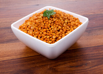 Fried and Spicy Chana Masala Dal, Chana Dal is a very popular Gujarati snack, white bowl on Wooden background