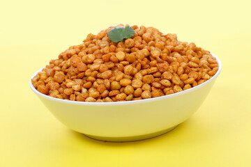 Fototapeta na wymiar Fried Salted Chana Dal, white bowl on Yellow background