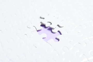 Blank white puzzle with separated piece on violet background