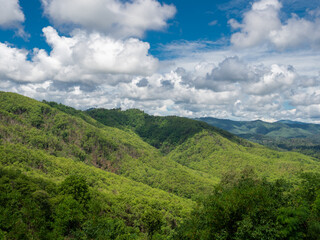 Fototapeta premium Beautiful green mountain landscape and vibrant blue sky with fluffy white clouds.