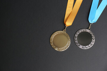 Gold and silver medals on black background, flat lay. Space for design