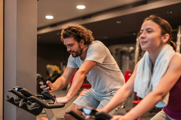 Man using a smart phone while working out in gym