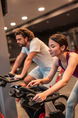 People cycling on gym bike machines