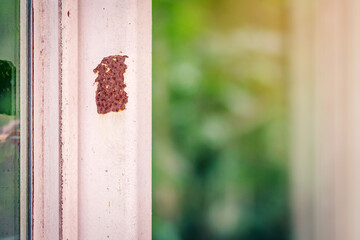 Close up of rust on an old white iron window with a blurred background