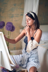 Young attractive girl painter getting inspiration from music
