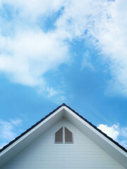 White vintage house with gable and against a blue sky