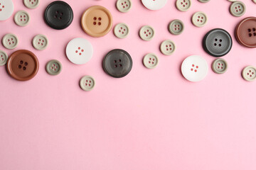 Fototapeta na wymiar Many sewing buttons on pink background, flat lay. Space for text