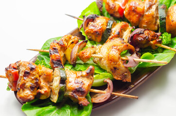 Grilled skewers with chicken, zucchini, mushrooms, peppers and onions served on iceberg lettuce