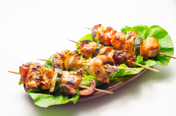 Grilled skewers with chicken, zucchini, mushrooms, peppers and onions served on iceberg lettuce