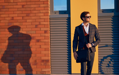 Elegant young businessman walking on city street