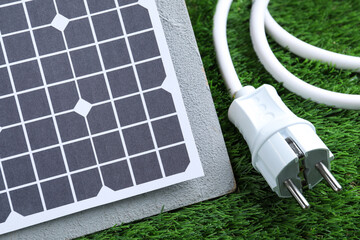 Solar panel and cable on green grass, closeup