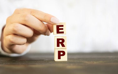 Businesswoman made word ERP with wood building blocks.