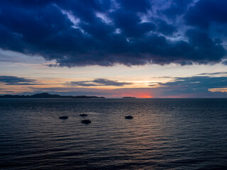 Obraz premium Silhouette of a boats in the middle of the ocean with dramatic sunset sky color.