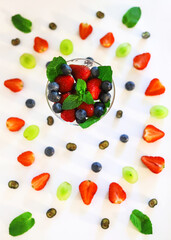 composition with berries and berry mixture in a crystal glass with strawberries, blueberries, blueberries and mint close-up