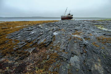 Abandoned old ship on the coast of the Arctic Ocean