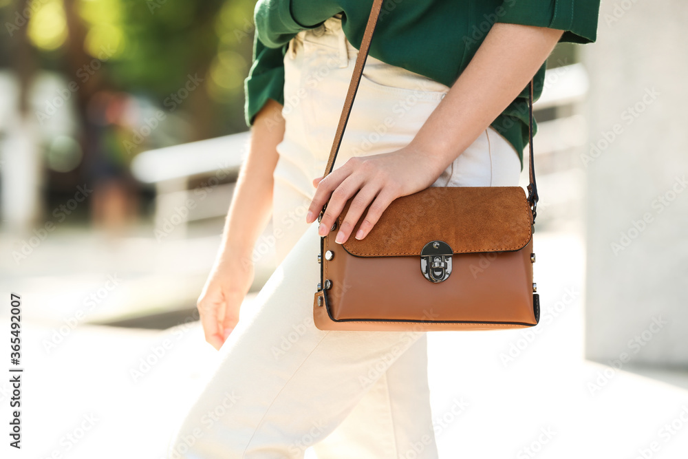 Wall mural Young woman with stylish leather bag outdoors on summer day, closeup