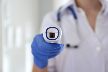Doctor holding non contact infrared thermometer indoors, focus on hand. Measuring temperature