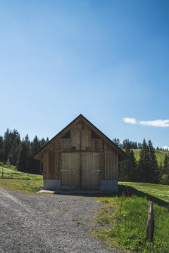 A barn in the Swiss mountains with blue sky in the background