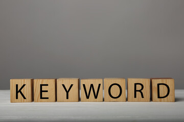 Word KEYWORD made of wooden cubes on grey background
